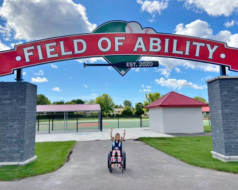 Young girl in a wheelchair at the entrance of Field of Ability